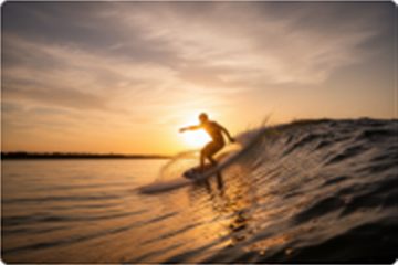 Wakesurfer riding a clean wave at sunset