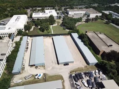 Secure covered boat storage building with easy access and tree-covered surroundings
