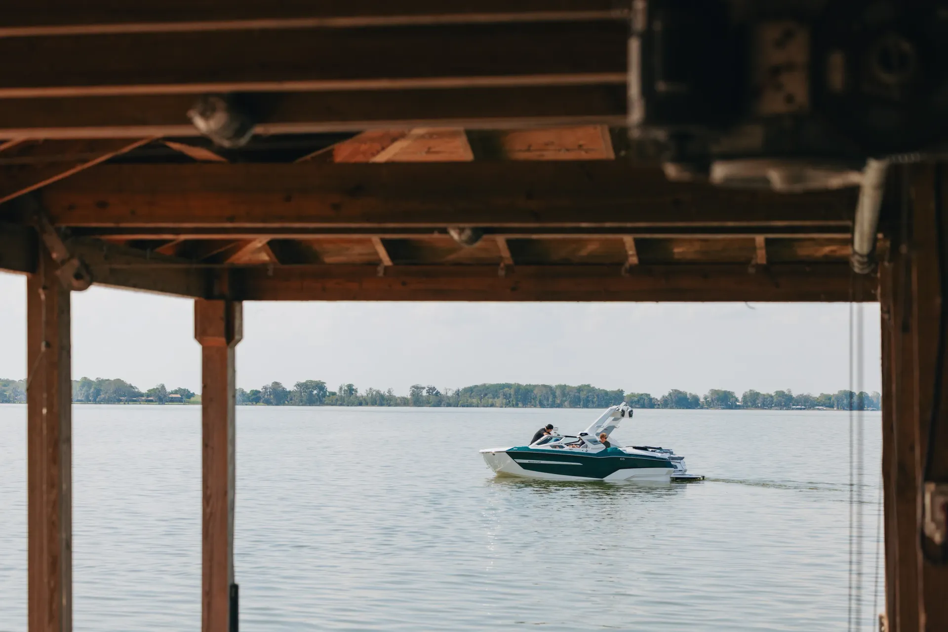 A boat cruising past a Riverside boathouse