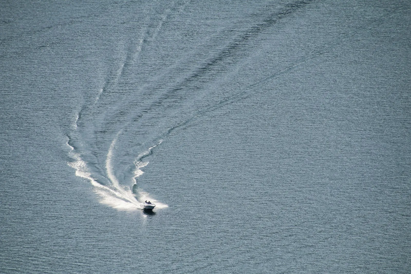 Boat cruising across open Idaho water at dusk