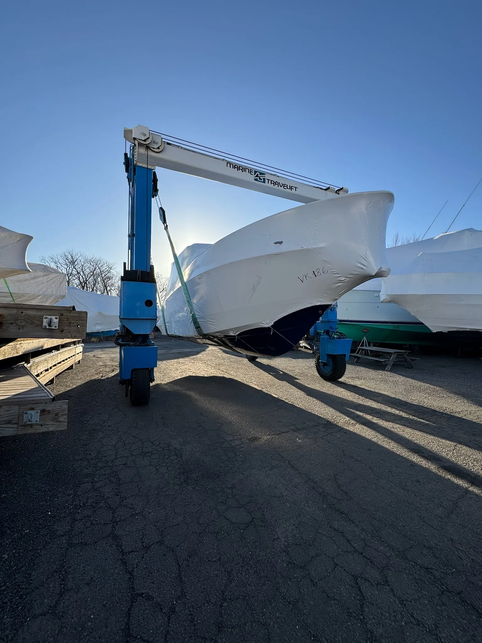 Technician installing a professional shrink-wrap cover on a boat at Petzold&rsquo;s