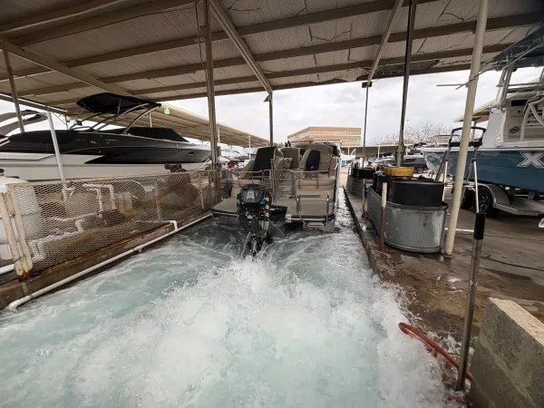 Modern boat service facility interior with multiple boats being serviced by certified technicians