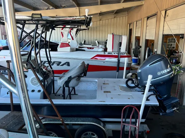 Certified marine technician inspecting boat hull for repairs