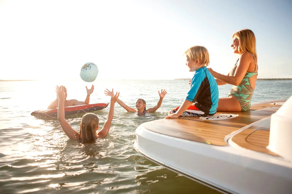 Family playing in the water off the swim platform