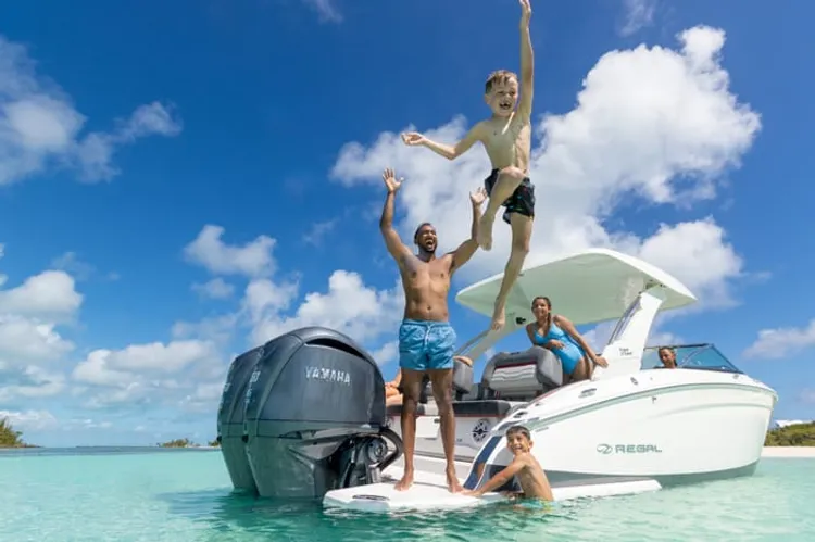 Friends jumping off a boat into the water