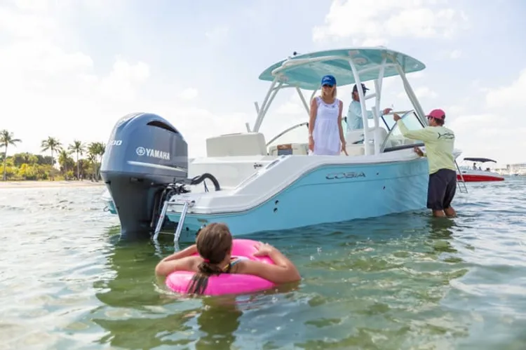 Swimmers in the water beside a boat
